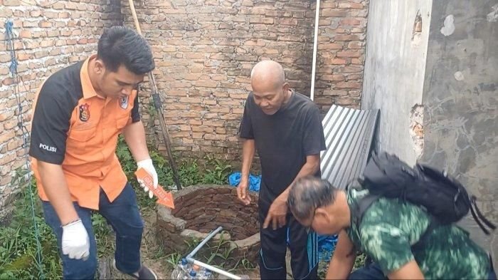Petugas saat melakukan oemeriksaan dilokasi sumur ditemukannya mayat wanita.