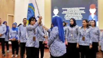 Ketua TP PKK Ny Darmawati Anton Achmad Saragih saat menyerahkan pataka kepada Pengurus yang baru dilantik.