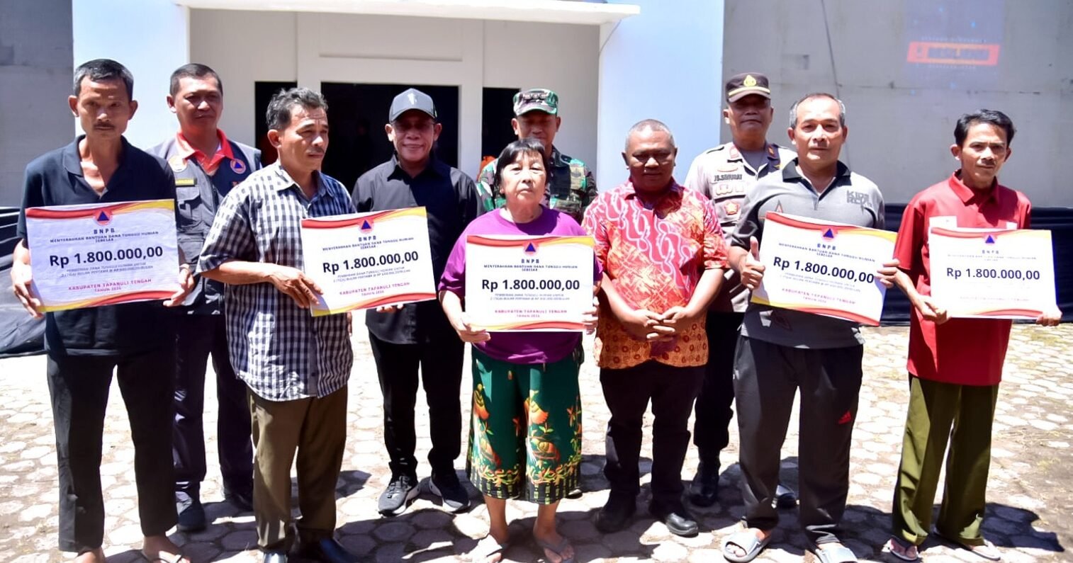 Bupati Tapteng Masinton Pasaribu saat menyerahkan Dana Tunggu Hunian (DTH) secara simbolis kepada warga yang terkena bencana, Kamis (5/2/2026).
