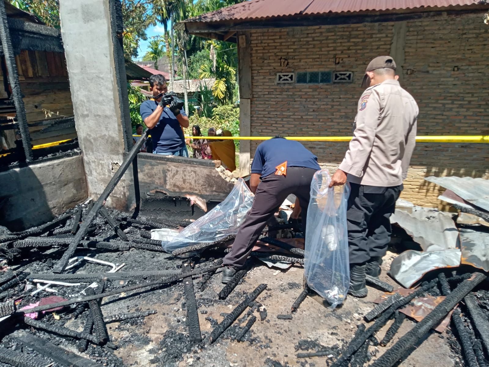 Personel Polsek Kolang bersama Tim INAFIS Polres Tapteng saat melakukan olah TKP pembakaran rumah di Dusun I Pargadungan, Kecamatan Tapian Nauli, Sabtu (07/02/2026).