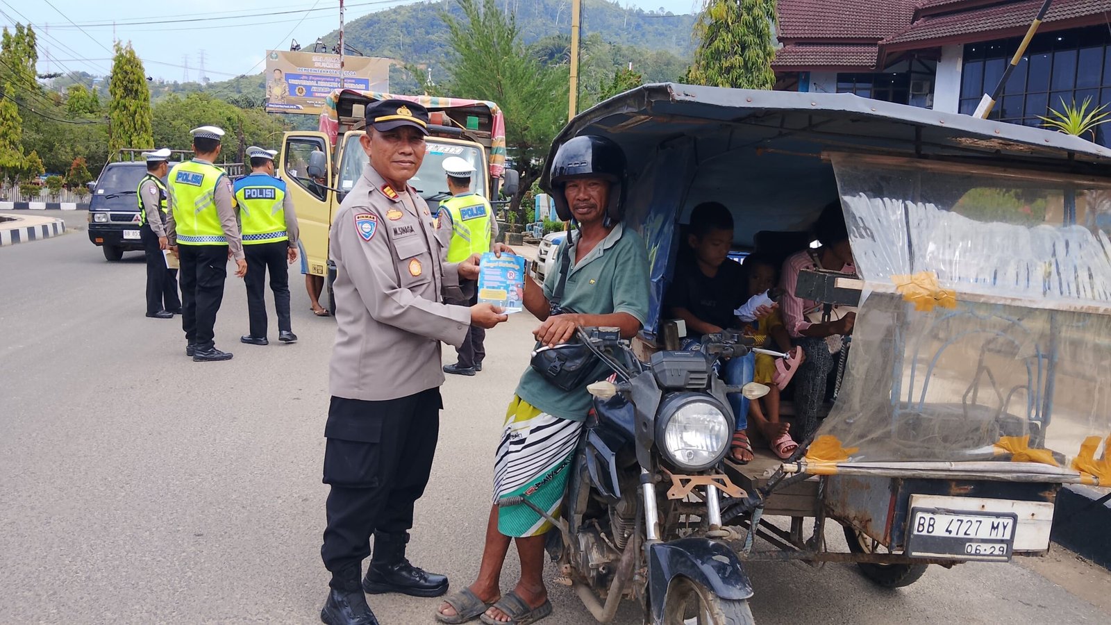 Personel Polres Sibolga saat membagikan brosur himbauan keselamatan berlalu lintas kepada pengendara kendaraan di jalan raya, Rabu (04/02/2026).