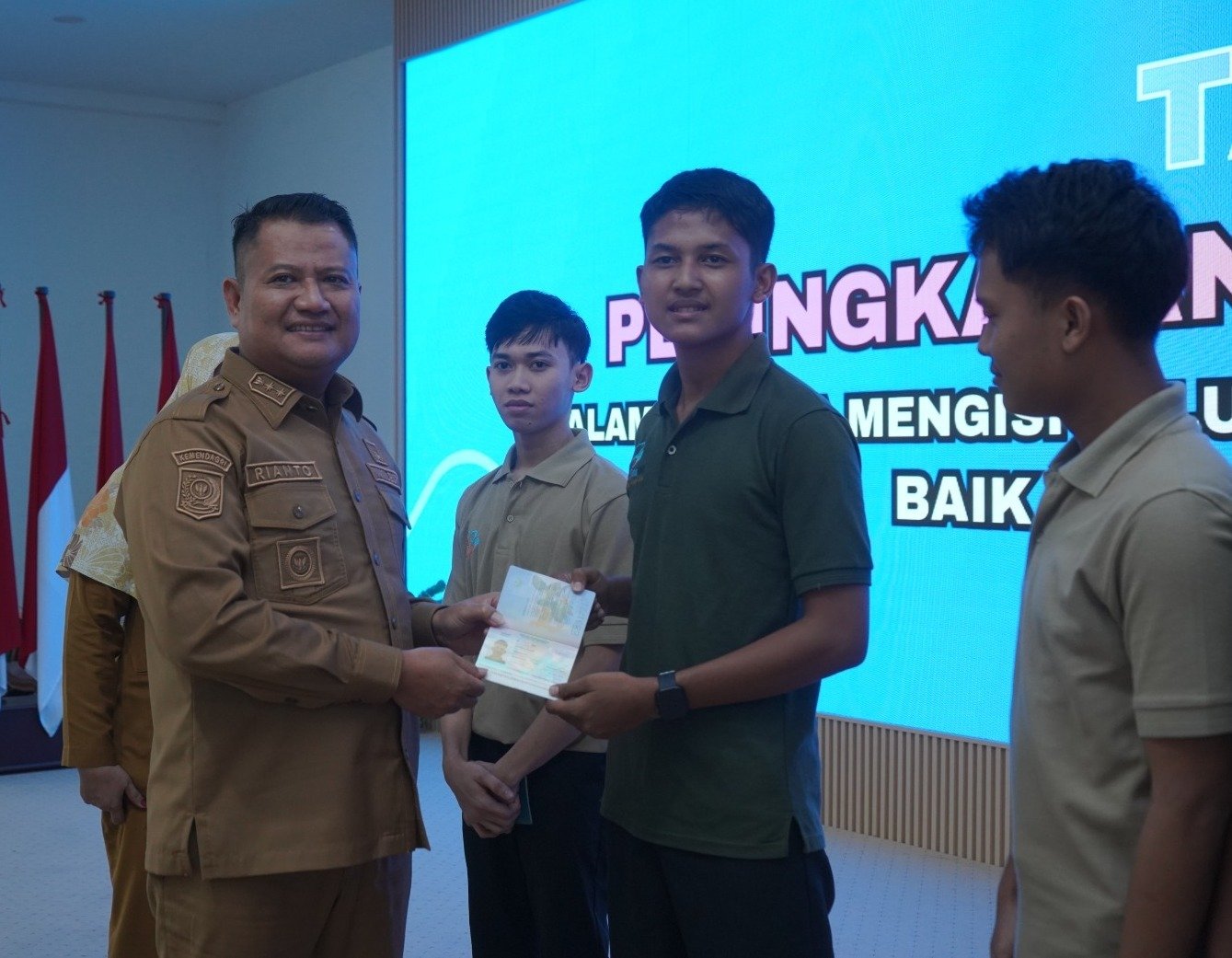 Salah seorang pencari kerja menerima Paspor dari Wakil Bupati Asahan Rianto.