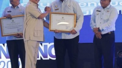 Muhammad Tito Karnavian ketika menyerahkan piagam penghargaan kepada Bupati Asahan Taufik Zainal Abidin.