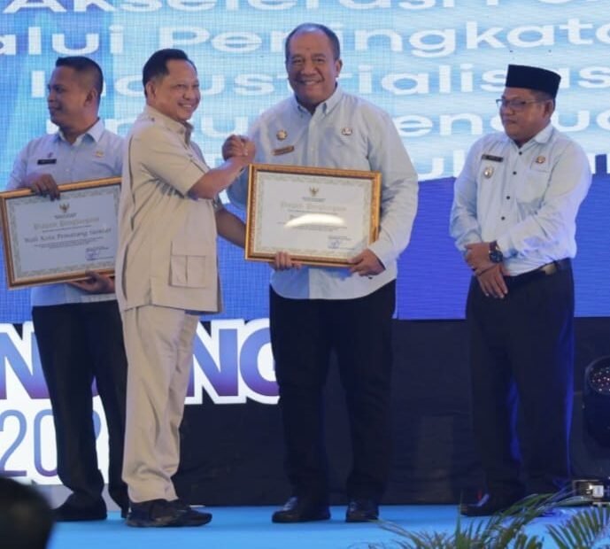 Muhammad Tito Karnavian ketika menyerahkan piagam penghargaan kepada Bupati Asahan Taufik Zainal Abidin.