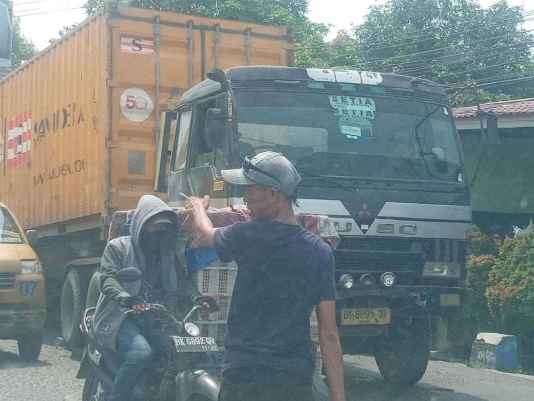 Truk mengangkut kontainer mogok di badan jalan tanjakan dekat jembatan sungai Tembung.